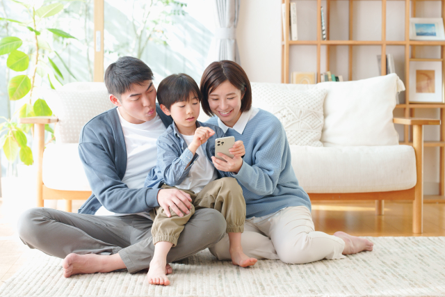 家族3人でスマホを見ている